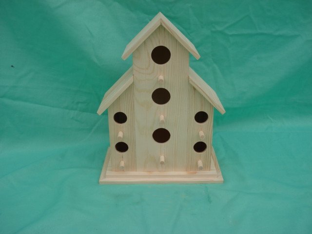 Multi-story tiered-roof wooden bird house with nine circular entrance holes for colony nesting