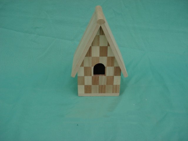 A-frame wooden bird house with checkerboard pattern walls and arched dark entrance