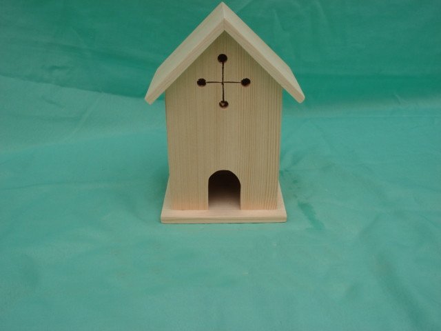Church-style wooden bird house with cross cutout decoration and arched entrance