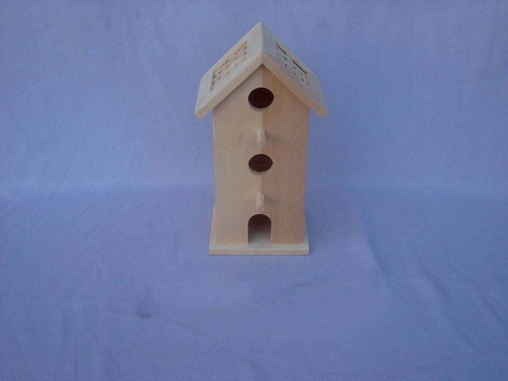 Tall wooden bird house with two square attic windows, circular entrance and arched door with perch