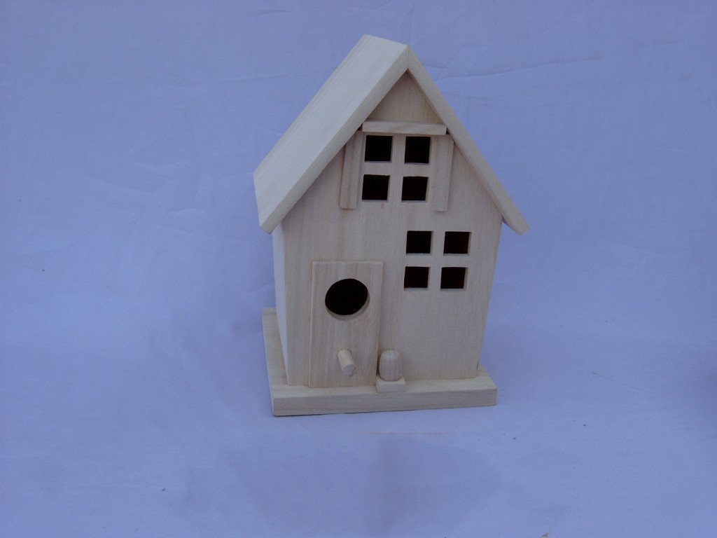 Cottage style wooden bird house with pitched roof, two shuttered windows and door with circular entrance