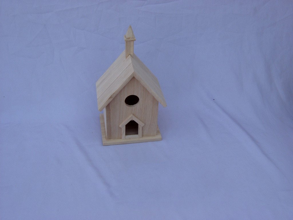 Wooden bird house with bell tower spire, peaked roof, round entrance and small arched door below