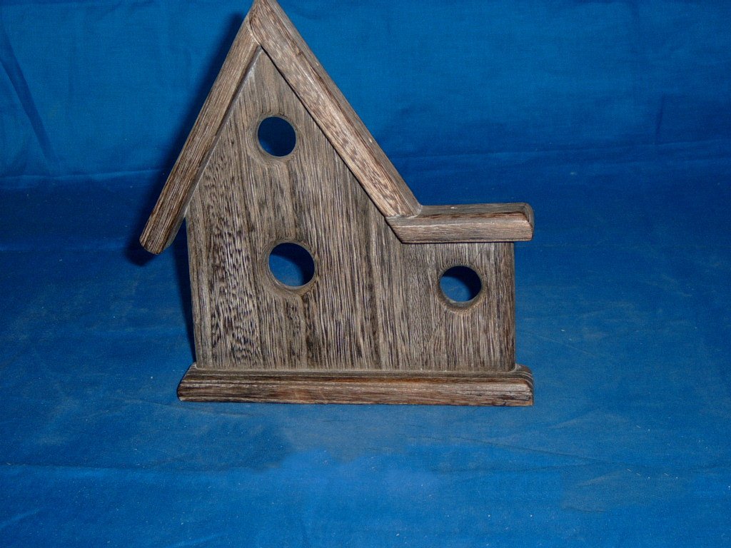 Driftwood-stained wooden bird house with three circular entrance holes and side wing extension
