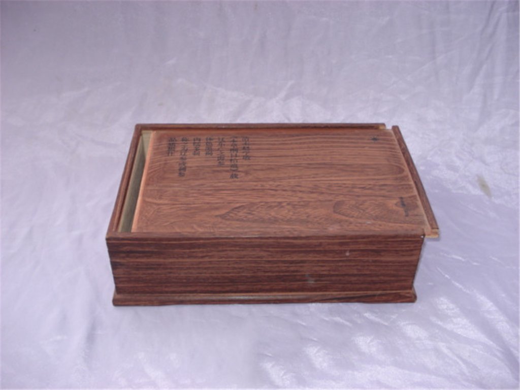 Long rectangular rosewood-style wooden box with Chinese character inscription carved into sliding lid