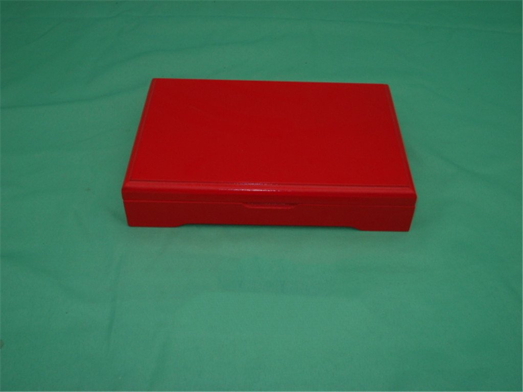 Large red lacquered wooden box with rounded corners, no visible hardware, on footed base