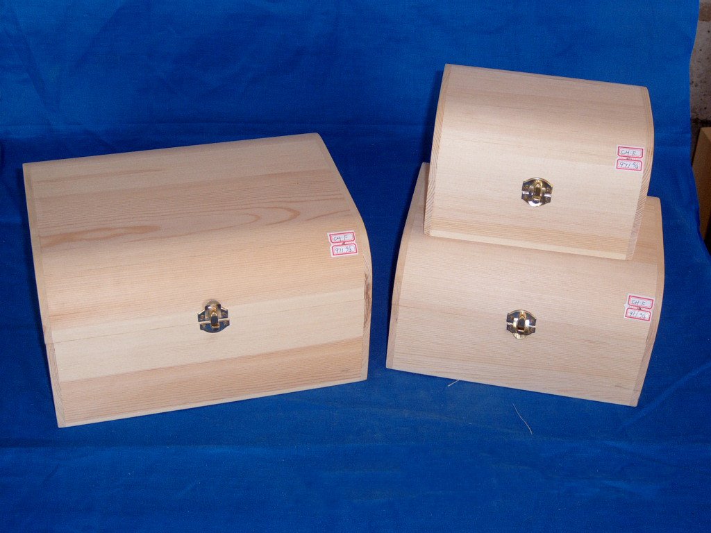Set of three domed natural-pine wooden boxes in different sizes with brass latches and small labels