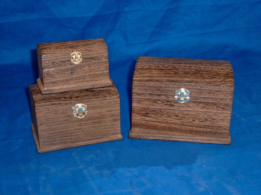 Set of three domed driftwood-stained wooden boxes in different sizes with brass latches