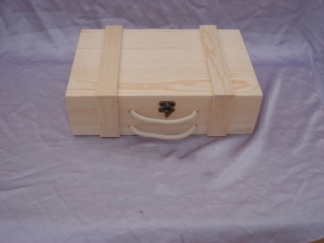 Closed rectangular natural-pine wooden wine box with two banded straps, rope side handle and brass latch