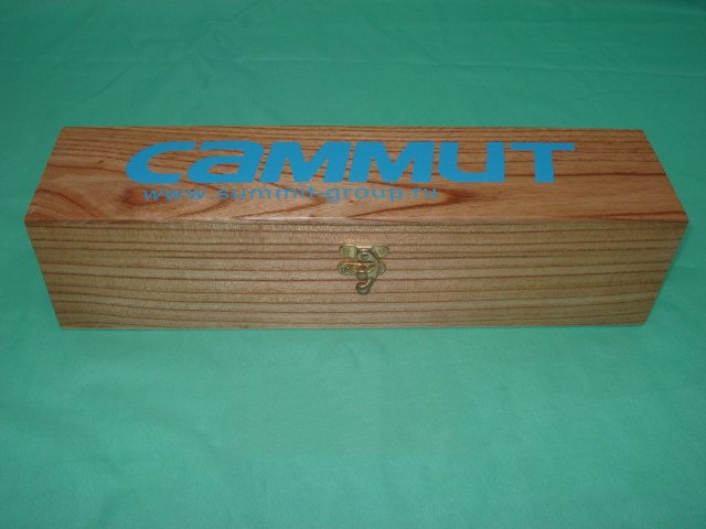Long flat rectangular medium-tone wooden wine box with CAMMUT painted logo and small brass clasp