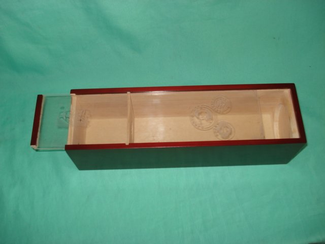Open long flat dark red lacquered wooden wine box showing internal divider and sliding lid with gold inlay label