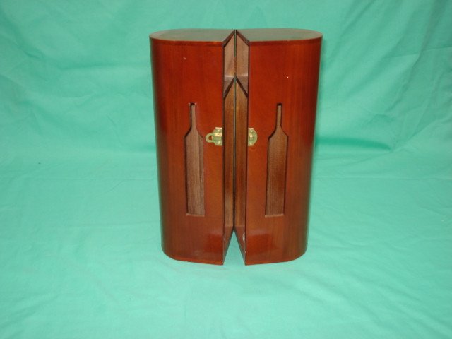 Two tall half-cylinder dark red lacquered single-bottle wooden wine boxes joined, each with bottle-shaped window and brass latch